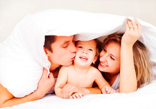 Famiglia felice sul letto